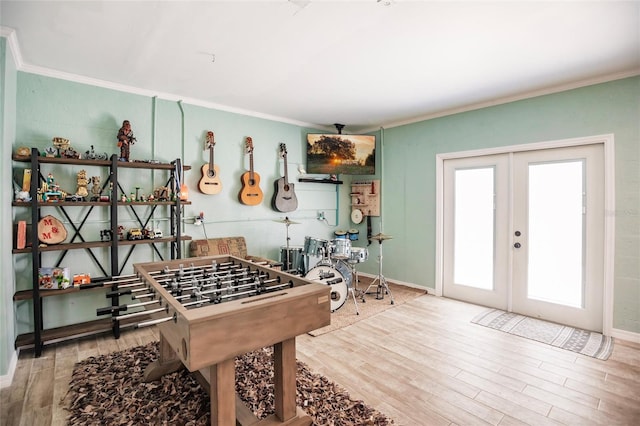 rec room with baseboards, ornamental molding, french doors, and wood finished floors