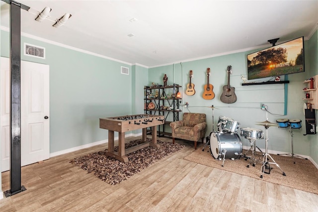 game room with ornamental molding, wood finished floors, and visible vents