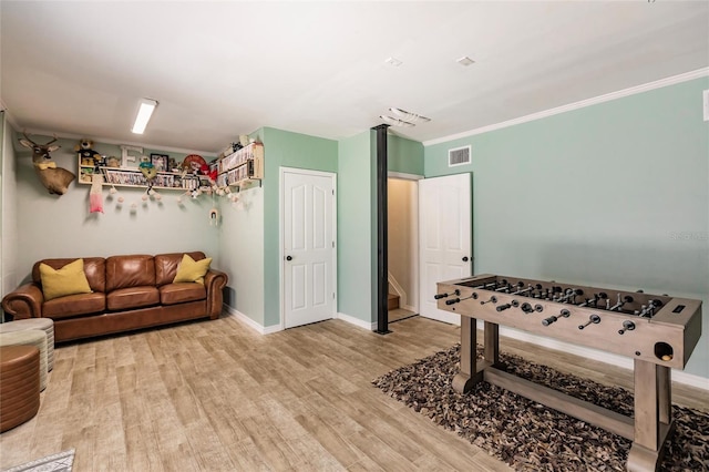 recreation room with visible vents, ornamental molding, baseboards, and wood finished floors