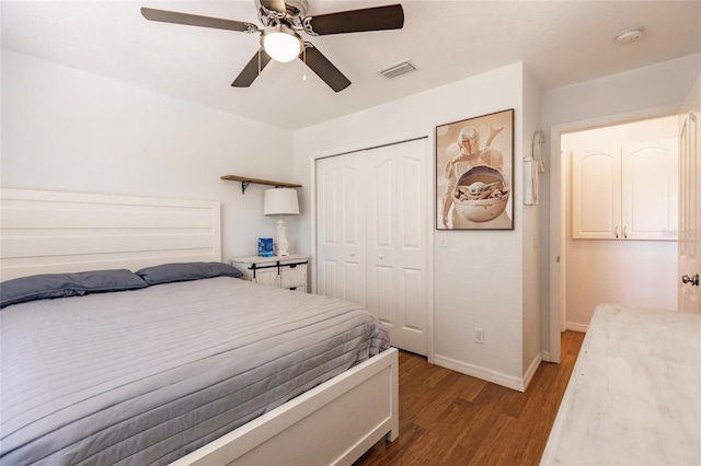 bedroom featuring visible vents, a closet, wood finished floors, baseboards, and ceiling fan