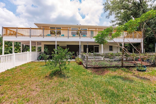 back of property featuring a yard, a deck, and fence