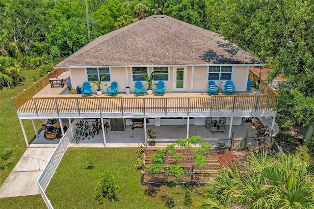 rear view of property with a yard, a wooden deck, a fenced backyard, and a patio area