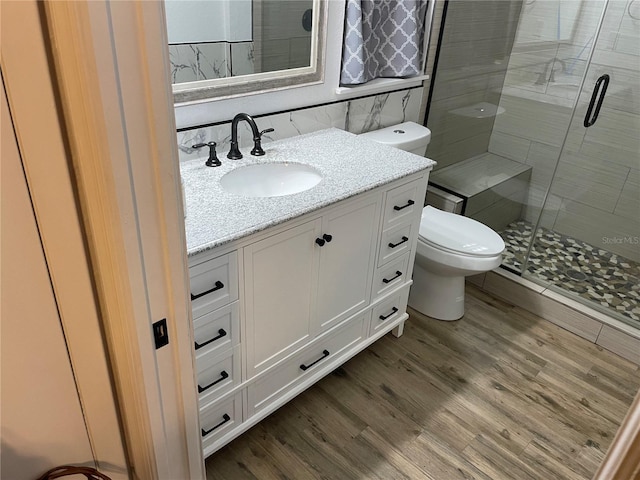full bath with vanity, wood finished floors, toilet, and a shower stall