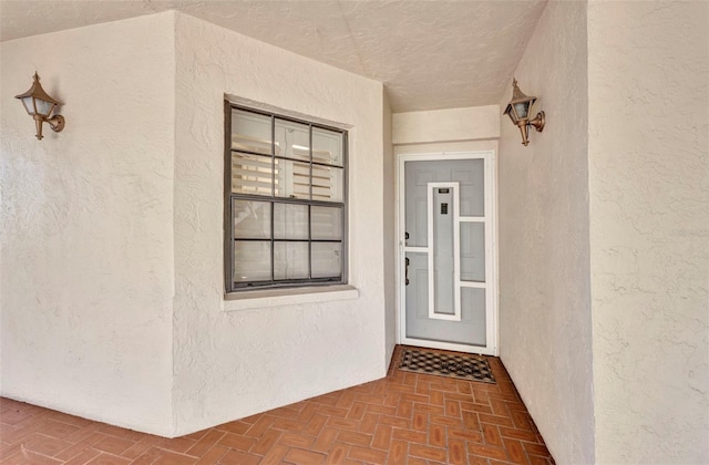 doorway to property featuring stucco siding