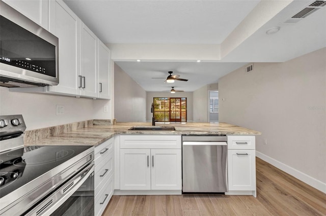 kitchen with visible vents, a ceiling fan, light wood-type flooring, a sink, and stainless steel appliances