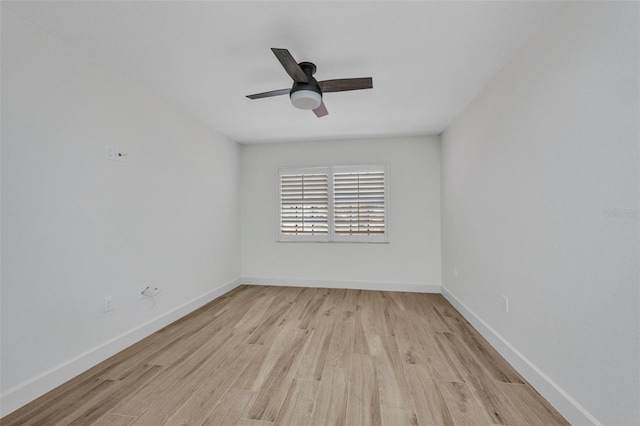spare room featuring a ceiling fan, baseboards, and light wood-type flooring