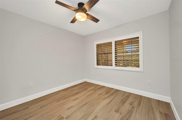 spare room featuring a ceiling fan, baseboards, and wood finished floors