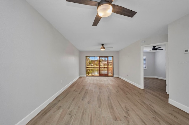 spare room featuring baseboards, ceiling fan, and light wood-style flooring