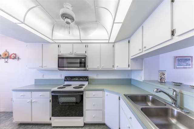 kitchen with a sink, stainless steel microwave, electric stove, light countertops, and white cabinets