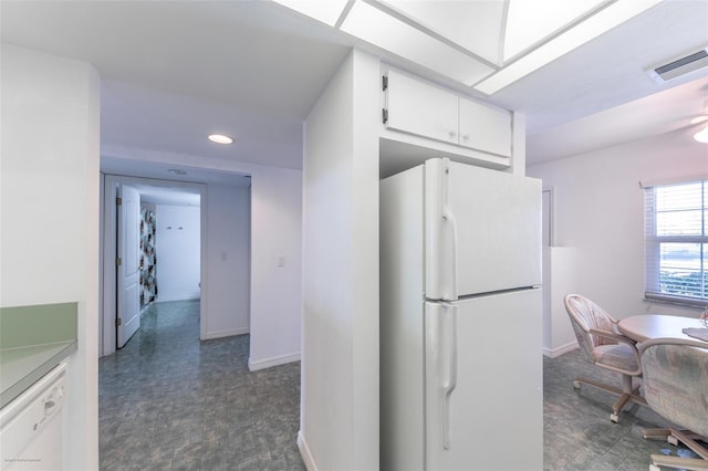 kitchen featuring freestanding refrigerator, baseboards, white cabinets, and recessed lighting