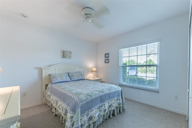 carpeted bedroom featuring baseboards and a ceiling fan