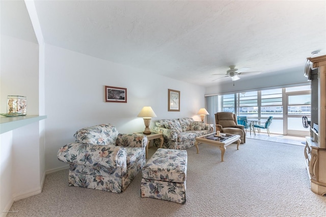 carpeted living room featuring baseboards and ceiling fan