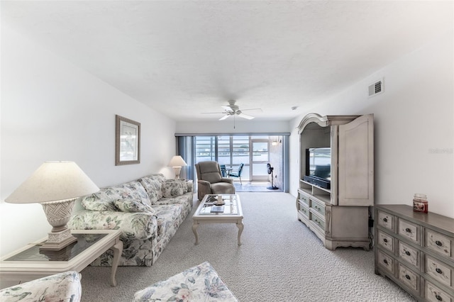 living area featuring ceiling fan, light carpet, and visible vents