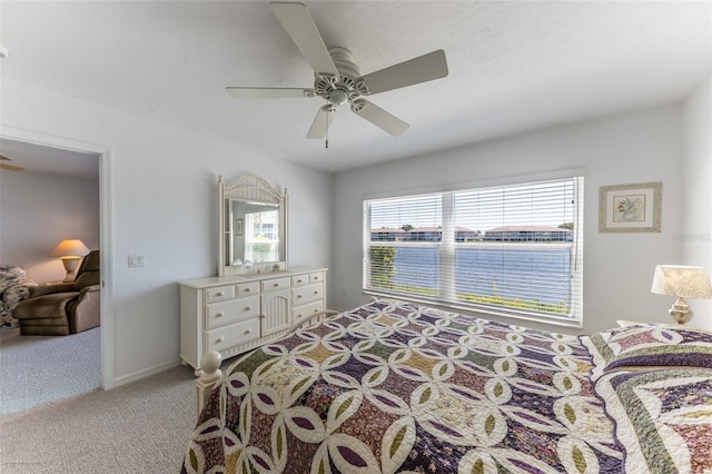 bedroom with light colored carpet, multiple windows, and a ceiling fan
