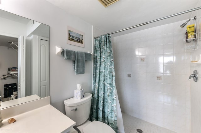 bathroom with a stall shower, vanity, toilet, and visible vents