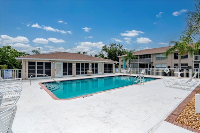 pool with a patio and fence