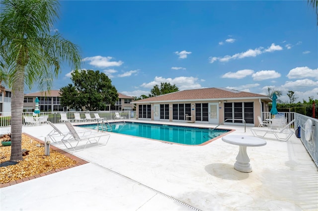 community pool featuring a patio area and fence