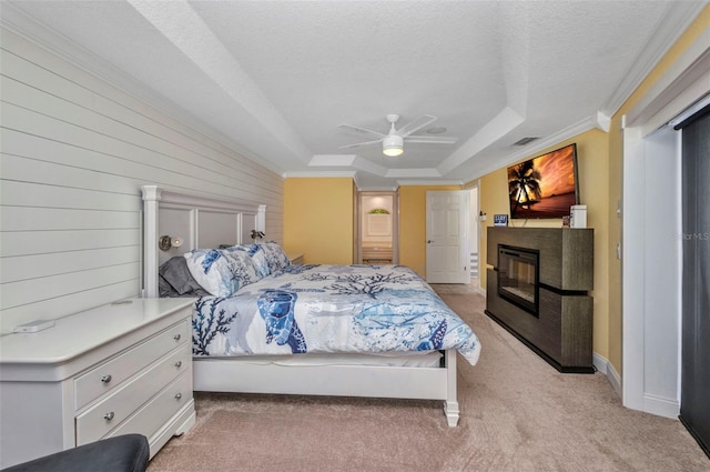 474 Lomond Dr, Port Charlotte, FL 33953 - bedroom featuring a tray ceiling, light carpet, a glass covered fireplace, a textured ceiling, and ceiling fan