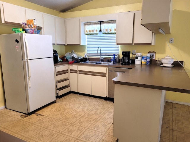 21161 Knollwood Ave, Port Charlotte, FL 33952 - kitchen featuring freestanding refrigerator, a peninsula, dark countertops, vaulted ceiling, and stainless steel dishwasher