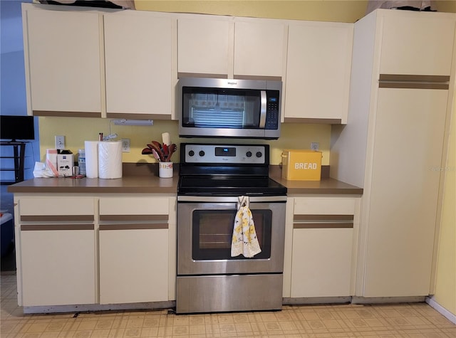 21161 Knollwood Ave, Port Charlotte, FL 33952 - kitchen featuring stainless steel appliances, white cabinets, light flooring, and dark countertops