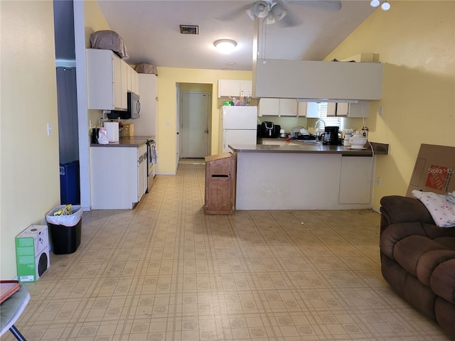 21161 Knollwood Ave, Port Charlotte, FL 33952 - kitchen with open floor plan, freestanding refrigerator, stainless steel microwave, a peninsula, and white cabinetry