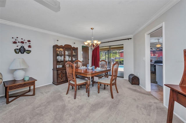 dining space with crown molding, baseboards, a notable chandelier, and light carpet