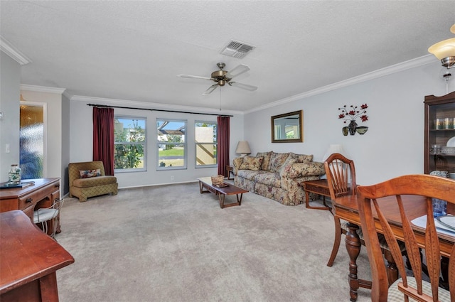 living room featuring visible vents, ornamental molding, carpet, and ceiling fan