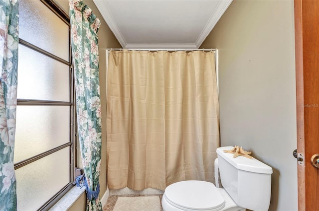 bathroom featuring crown molding, toilet, and curtained shower