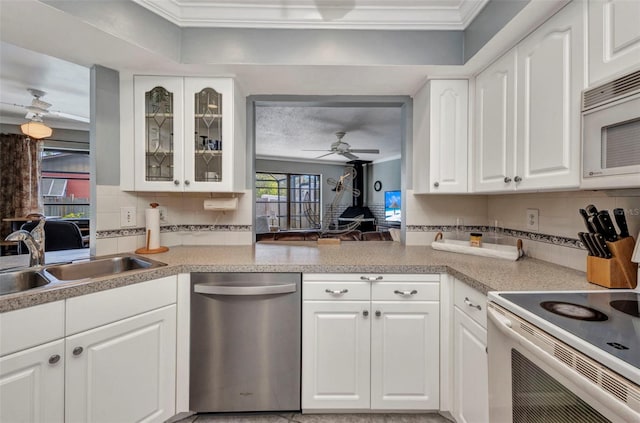 kitchen featuring crown molding, a sink, white appliances, a ceiling fan, and backsplash