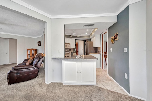 kitchen with visible vents, ornamental molding, and white cabinetry