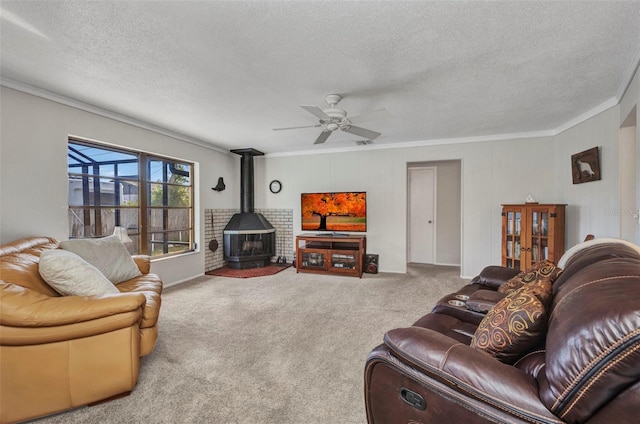 living room featuring a textured ceiling, carpet, ornamental molding, and a wood stove