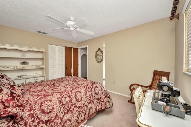 carpeted bedroom featuring visible vents, a closet, baseboards, ceiling fan, and arched walkways