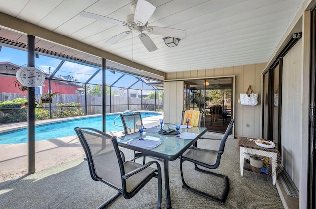 exterior space featuring a ceiling fan, a patio area, glass enclosure, fence, and a fenced in pool