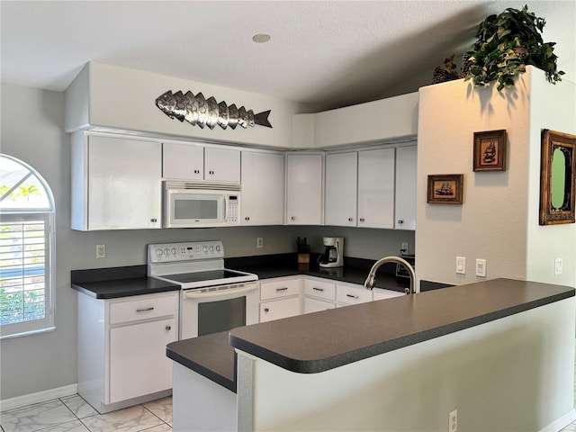1025 Boundary Blvd, Rotonda West, FL 33947 - kitchen featuring dark countertops, a sink, white appliances, marble finish floor, and a peninsula