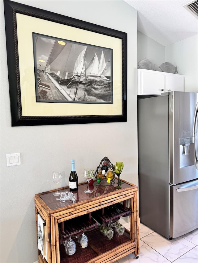 1025 Boundary Blvd, Rotonda West, FL 33947 - details with stainless steel refrigerator with ice dispenser, visible vents, and white cabinetry