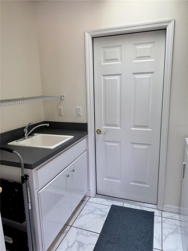 1025 Boundary Blvd, Rotonda West, FL 33947 - laundry room featuring a sink and marble finish floor