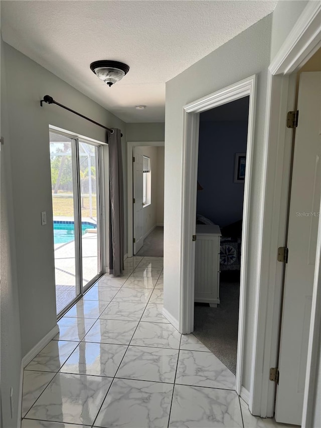 1025 Boundary Blvd, Rotonda West, FL 33947 - hall featuring baseboards, a textured ceiling, and marble finish floor