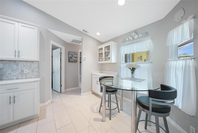 dining room with vaulted ceiling, baseboards, and recessed lighting