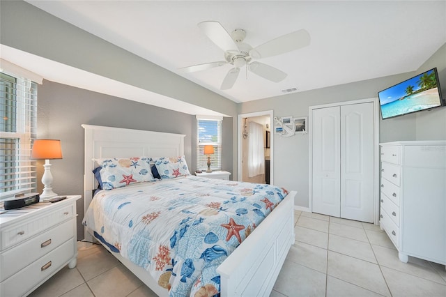 bedroom with light tile patterned flooring, ceiling fan, and a closet