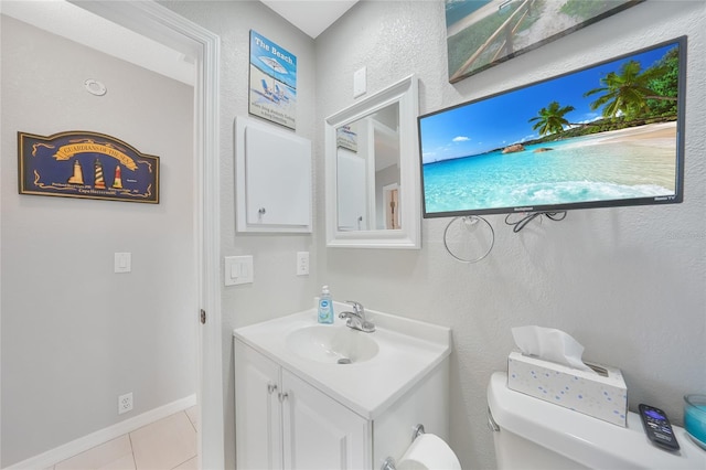 bathroom with toilet, tile patterned flooring, vanity, and baseboards