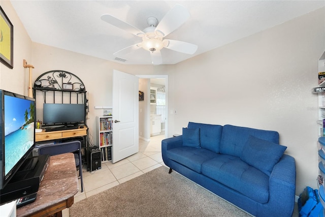 living area with light tile patterned floors and a ceiling fan
