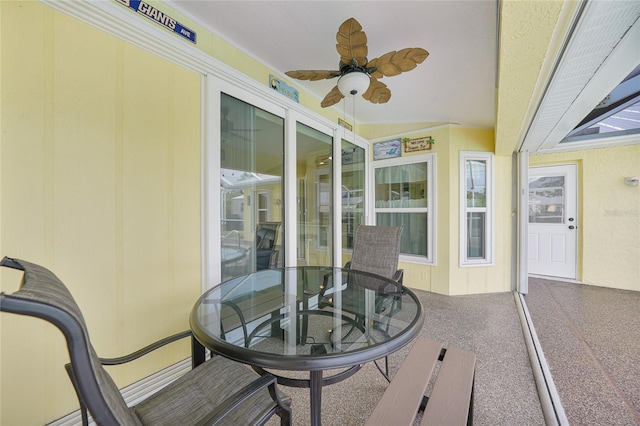sunroom / solarium featuring ceiling fan and outdoor dining space