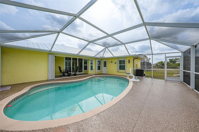 swimming pool featuring a patio and glass enclosure