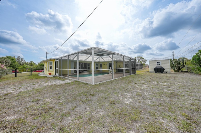 view of yard featuring an outdoor pool, a lanai, an outbuilding, a shed, and fence