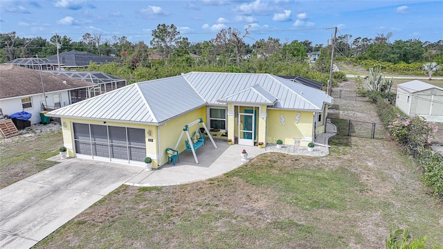 view of front facade featuring stucco siding, a standing seam roof, an attached garage, and driveway