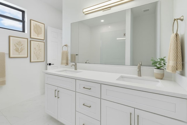 full bath with double vanity, a sink, marble finish floor, and walk in shower