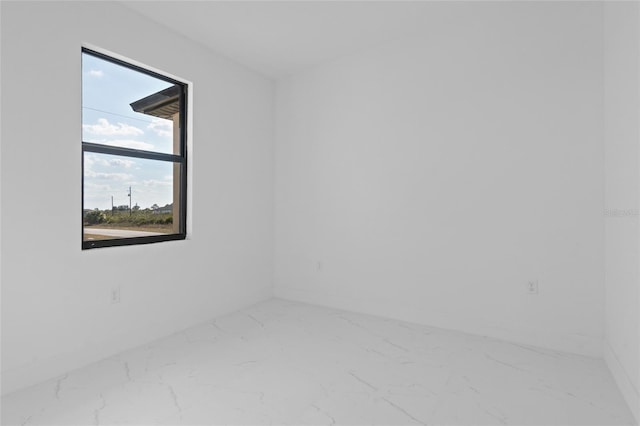 unfurnished room featuring baseboards and marble finish floor