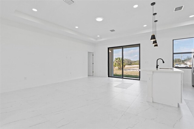 interior space featuring a sink, a raised ceiling, recessed lighting, and visible vents