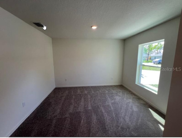 carpeted empty room with baseboards, recessed lighting, a textured ceiling, and visible vents