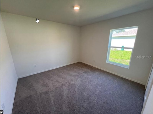 carpeted empty room with baseboards